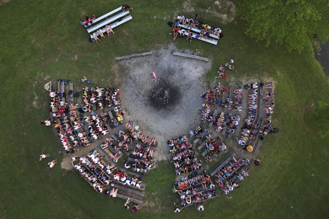 Campers and counselors sit at the campfire ring, Thursday, June 20, 2024, at YMCA Camp Kern in Oregonia, Ohio.